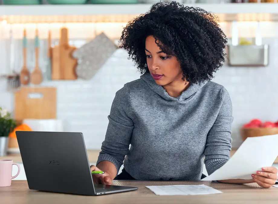 Kobieta pracująca na laptopie Dell XPS 14 w kuchni